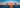 Blue-framed glasses on a reflective surface with a sunset or sunrise in the background